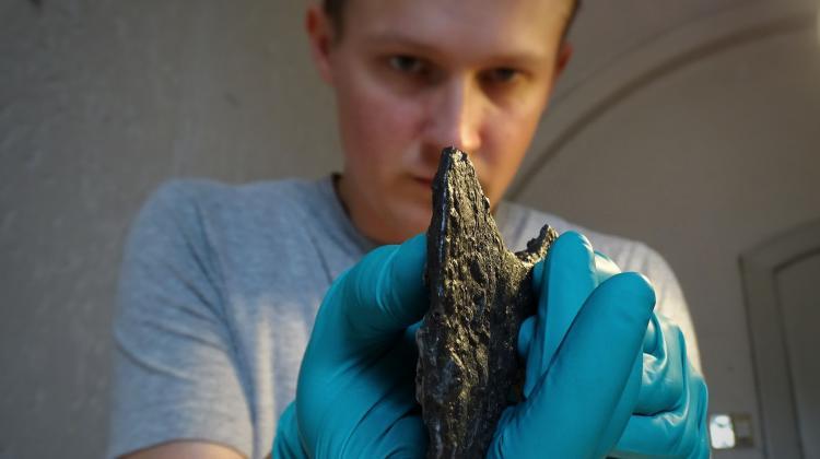 Danemark - Le Dr Leszek Gardela examine la tête de hache découverte dans la tombe d'une femme slave à Bogøvej - Photo: Mira Fricke