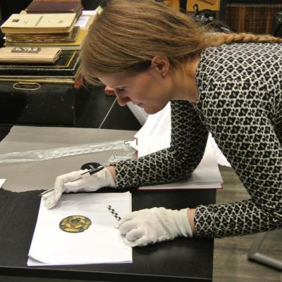 Norvège - Aina Margrethe Heen Pettersen examine un des objets découverts à Vang - Photo: Opdalingen